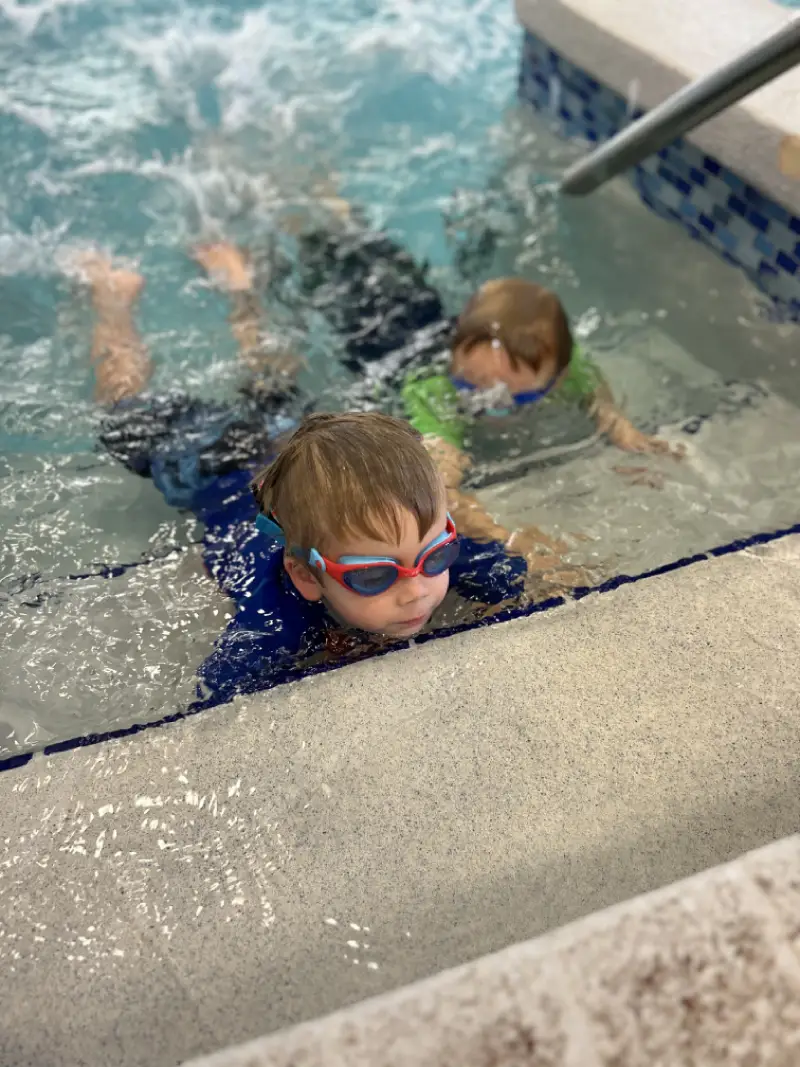 happy childrens group at swimming pool class learning to swim