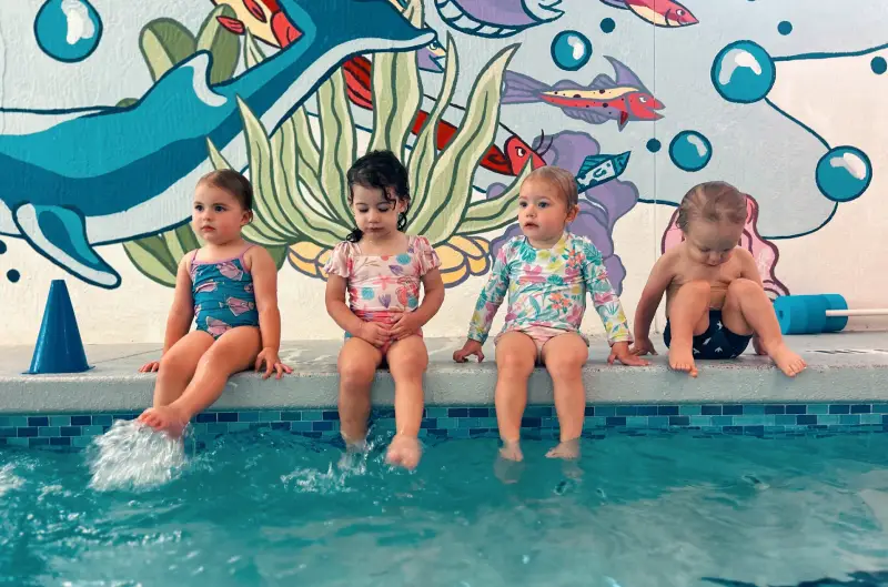 Group lessons - kids splashing at the side of the pool