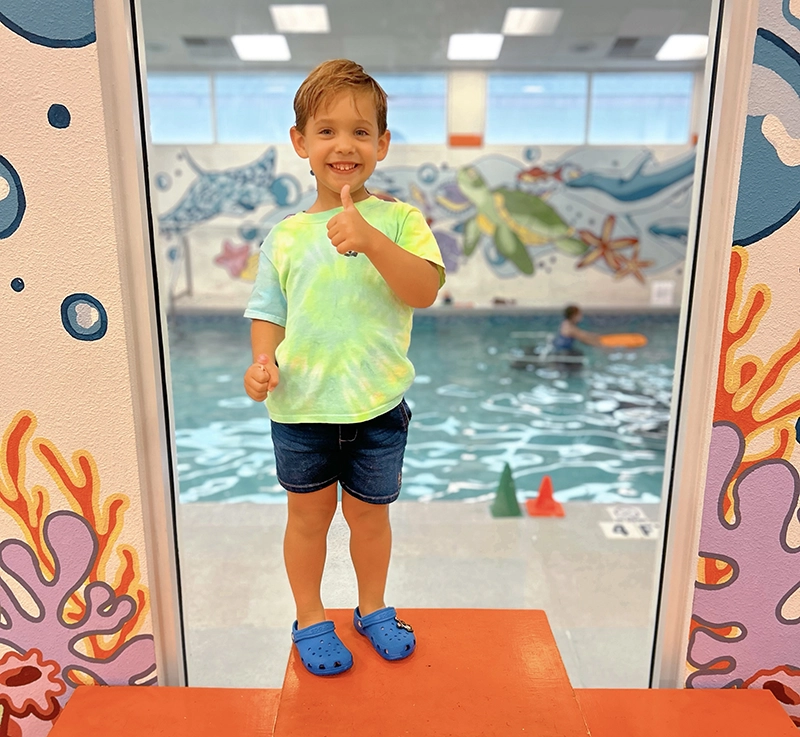 Little tyke giving the thumbs up before his Parent and Me swim lesson
