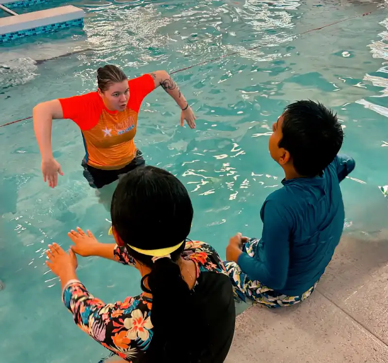 top view of a 7-year boy swimming backstroke in a swimming pool