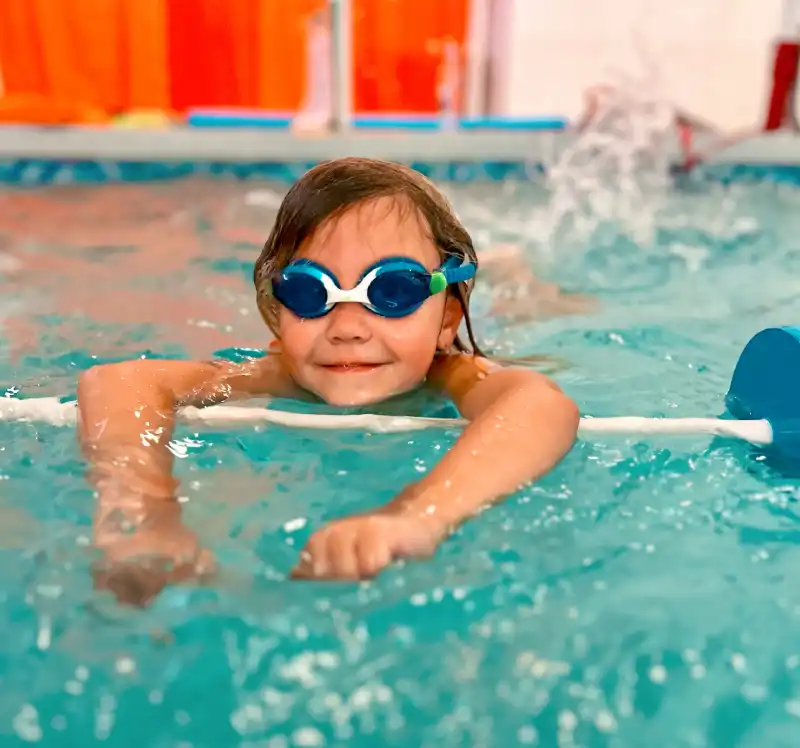 Swimmers puts on a goggles in swimming pool